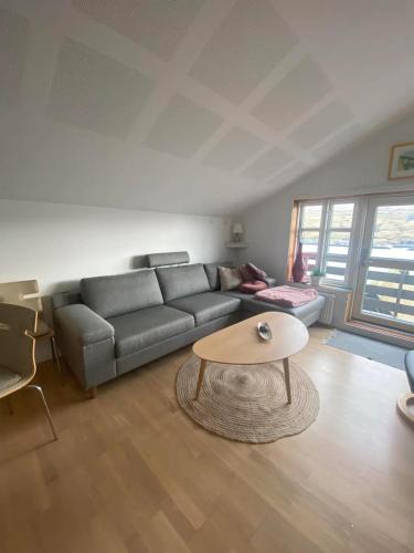 a living room with a couch and a coffee table at Mariustova close to the airport in Ryggur