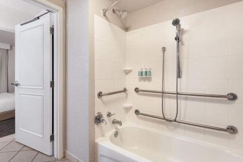 a bathroom with a shower and a bath tub at Residence Inn by Marriott Daytona Beach Speedway/Airport in Daytona Beach