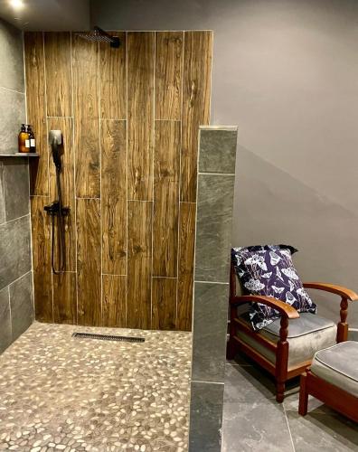 a bathroom with a shower with a wooden wall at Piers Villa 2 in Harare
