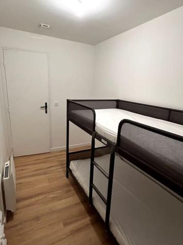 a room with two bunk beds and a door at Appartement proche La Bresse in Cornimont