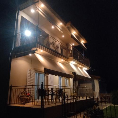 a house with a balcony at night with lights at Mary's Home in Asproklissi