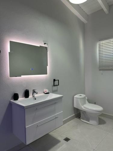 a white bathroom with a sink and a toilet at Executive Inn Aruba Room Swiss #5 in Oranjestad