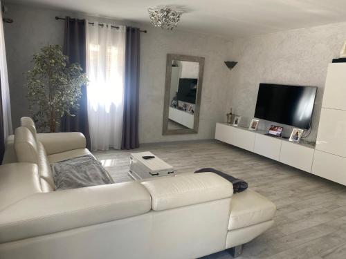 un salon avec un canapé blanc et une télévision dans l'établissement Maison, hauteur de Nimes, à Mas-de-Ponge