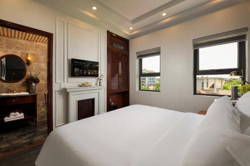 a bedroom with a white bed and a fireplace at Tam Coc Mountain Sunset and Garden Hotel in Ninh Binh
