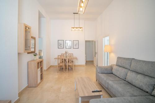 una sala de estar con un sofá y una mesa en Piso en el Casco Histórico, en Sanlúcar de Barrameda