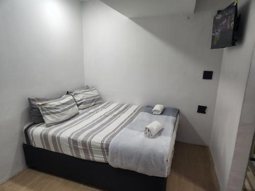 a small white bedroom with a bed with two pillows at East Park Inn in Polokwane