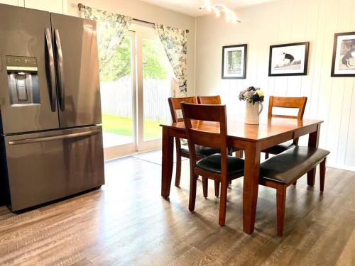 a kitchen with a table and a stainless steel refrigerator at Private Ranch- Entire Home - Hot Tub - Pets & Kids Welcome - King Bed - Fenced Backyard - Free WiFi in Gahanna