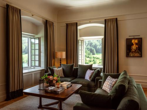 a living room with a couch and a table at Rosewood Schloss Fuschl in Hof bei Salzburg