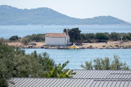 a small house on a island in the water at APARTMAN MAKSAN in Pakoštane