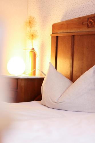 a bed with a wooden headboard and a white pillow at Ferienhof Mayischhof in Lauperath
