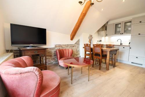 a living room with a tv and a table and chairs at Ferienhof Mayischhof in Lauperath