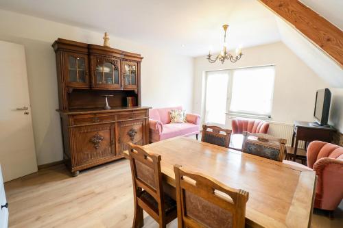 a dining room with a wooden table and chairs at Ferienhof Mayischhof in Lauperath