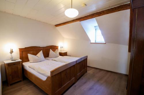a bedroom with a wooden bed with a window at Ferienhof Mayischhof in Lauperath
