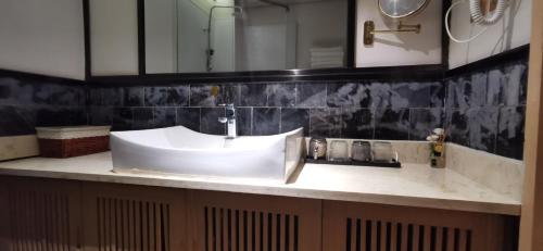 a bathroom with a white sink and a mirror at 嵩山居-丽晶精品民宿 in Dengfeng