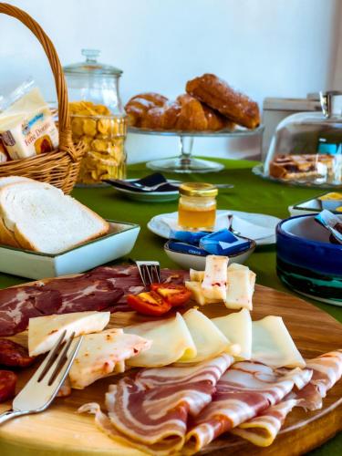 een tafel met kaas en vleeswaren op een snijplank bij Torre Galli-Dimora di Campagna in Gasponi