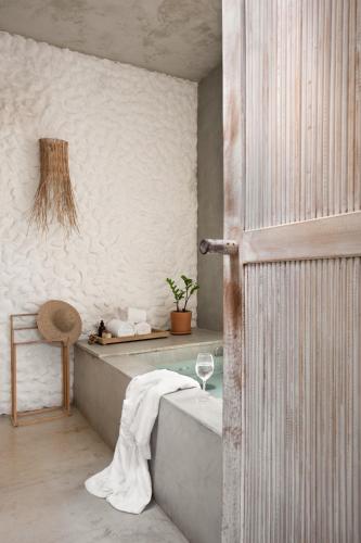 a bathroom with a tub and a glass table at Pousada Zinga Vila de Caraíva in Caraíva