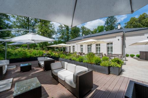 a patio with chairs and tables and umbrellas at Separé v zahradě in Ratměřice