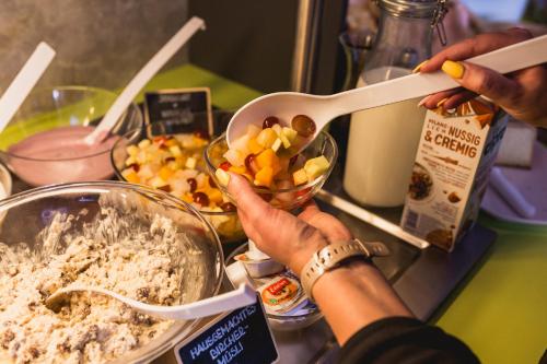 a person holding a bowl of food on a counter at SleepySleepy Hotel Dillingen in Dillingen an der Donau