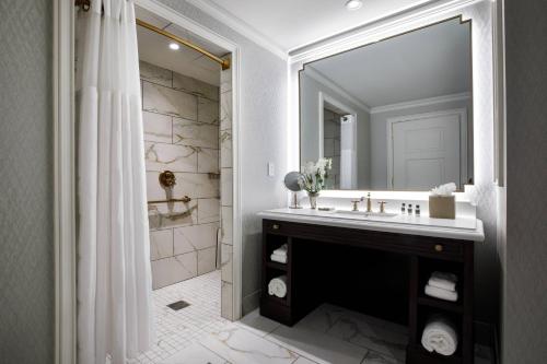 a bathroom with a sink and a large mirror at Hotel Carmichael, Autograph Collection in Carmel