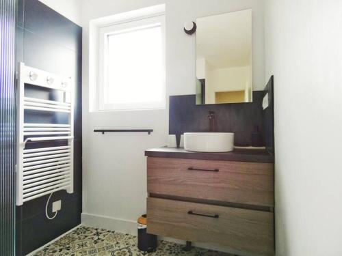 une salle de bain avec un lavabo et un miroir dans l'établissement Maison à la campagne - 2 chambres - jardin, à Bauzy