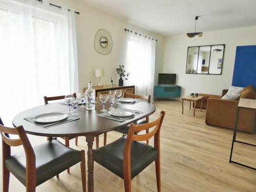 une table à manger et des chaises dans un salon dans l'établissement Maison à la campagne - 2 chambres - jardin, à Bauzy