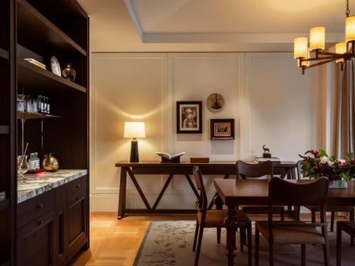 a dining room with a table and a desk at Rosewood Schloss Fuschl in Hof bei Salzburg