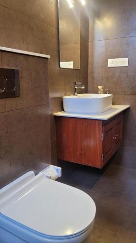 a bathroom with a white sink and a toilet at tippys beach resort in Kovalam