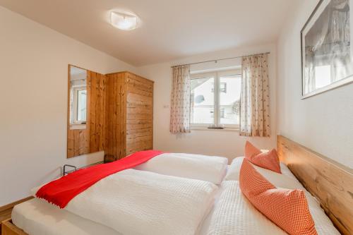 een slaapkamer met 2 witte bedden en een raam bij Ferienwohnungen Barbara in Stumm