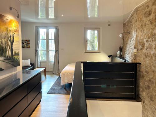 a bedroom with a bed and a sink in a room at Villa Authentique et Architecturale - Centre Ville in Forcalquier