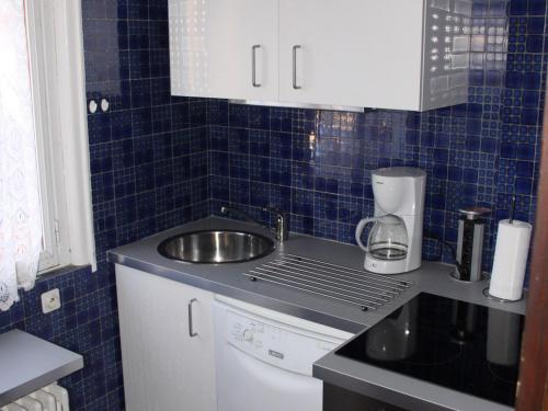 une cuisine avec un évier et du carrelage bleu au mur dans l'établissement Appartement 3 pièces 6 personnes, 3 étoiles, exposition Sud, centre Valloire - FR-1-263-73, à Valloire