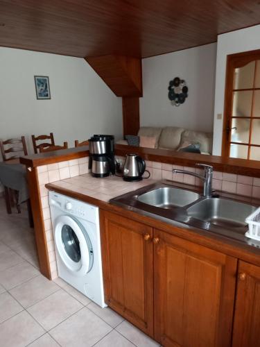 a kitchen with a sink and a washing machine at Maison des trois ormeaux in Cier-de-Luchon