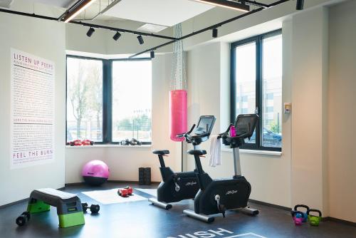 a gym with two exercise bikes and a ball at Moxy Amsterdam Schiphol Airport in Hoofddorp