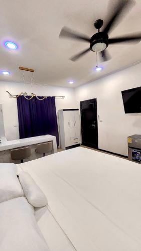 a bedroom with a large bed with a ceiling fan at H et L in Tortuguero