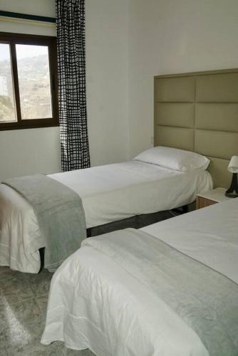 a hotel room with two beds and a window at El Granero in Moya