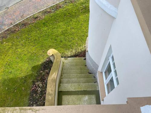 a staircase leading up to a building with green grass at Villa Deichvoigt in Cuxhaven