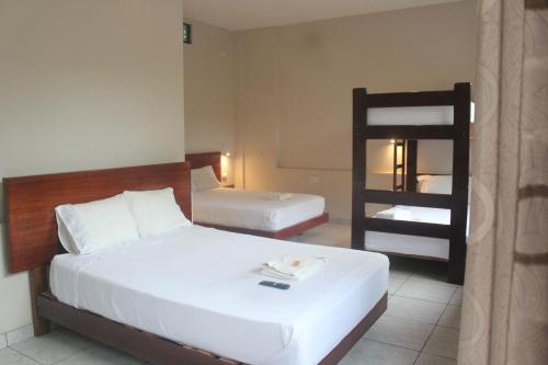 a bedroom with two beds and a bunk bed at Amazon City in Pucallpa