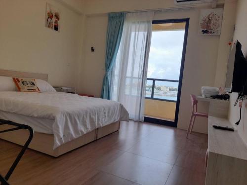 a bedroom with a bed and a sliding glass door at Shuye Mumu BnB in Magong