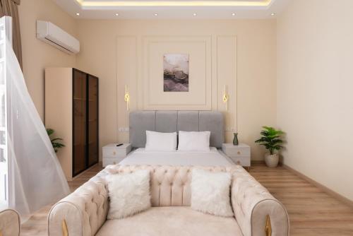 a white bedroom with a large bed and a couch at Museum Studios in Cairo
