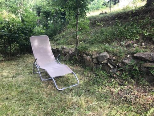a chair sitting in the grass in a field at Les Orres Appartement dans le hameau du Mélezet in Les Orres