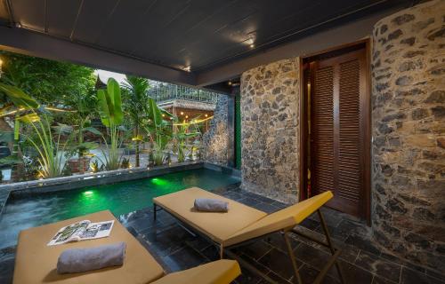 a patio with a table and chairs and a swimming pool at Tam Coc Mountain Sunset and Garden Hotel in Ninh Binh
