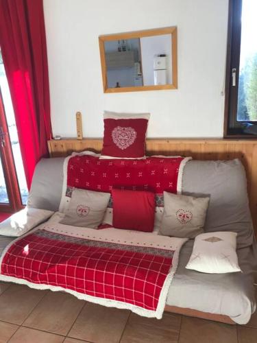 a couch with pillows on it in a room at Les Orres Appartement dans le hameau du Mélezet in Les Orres