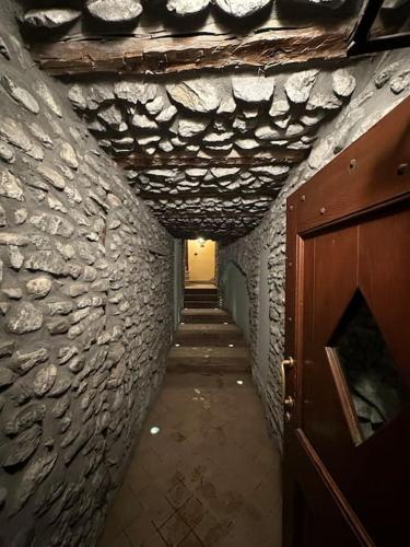 a hallway of a stone building with a wooden door at Vicino alle piste, Moderno e Centrale monolocale in Cesana Torinese