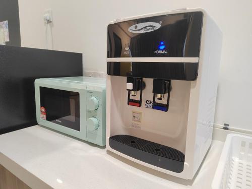 a coffee machine next to a microwave on a counter at Seaview Infinity Pool , 40th , 9pax, 3Rooms 2Carpark in Jelutong