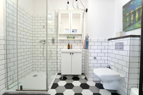 Un baño blanco con ducha y WC. en Wodniak, en Ostróda