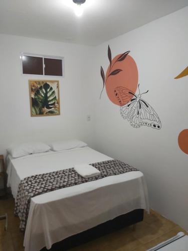 a bedroom with a bed with a butterfly on the wall at Pousada Mangai in João Pessoa