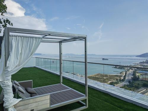 a balcony with a hammock and a view of the ocean at Seaview Infinity Pool , 40th , 9pax, 3Rooms 2Carpark in Jelutong
