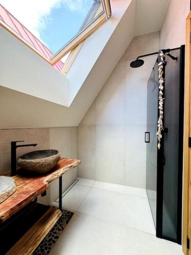a bathroom with a skylight and a shower with a sink at Stylish seaside home in Palanga in Kunigiškiai