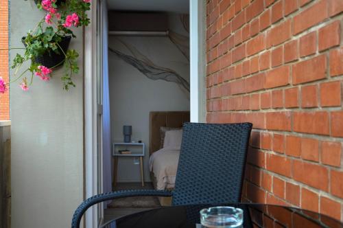 a table and a chair in front of a brick wall at Eva apartman in Gornji Milanovac