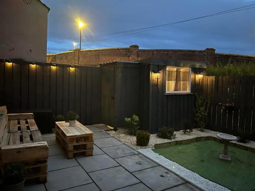 une arrière-cour avec une clôture noire et une table en bois dans l'établissement 23 Innes Street Apartment, à Inverness