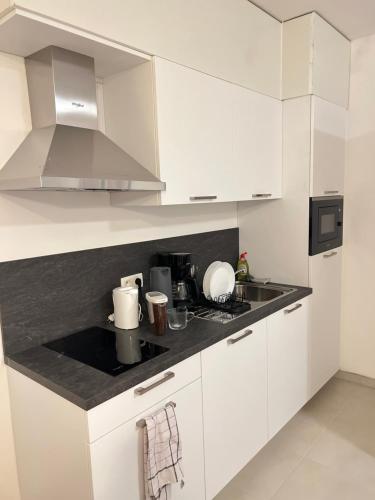 a kitchen with white cabinets and a counter top at Hote Brussels center City luxe Tours et Taxi in Brussels